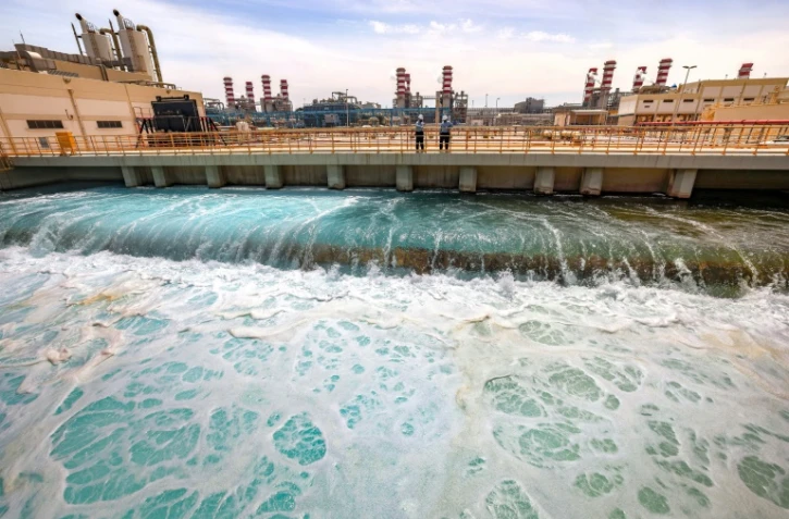 Deux employés de l'usine de dessalement de Ras al-Khaïr discutent le 30 mars 2023 dans cette installation située dans l'est de l'Arabie saoudite