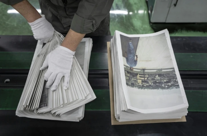 Un employé emballe l'œuvre du photographe Kazuma Obara, "The Newspaper", à Kumiyama, dans la préfecture de Kyoto, au Japon, le 19 mars 2026
