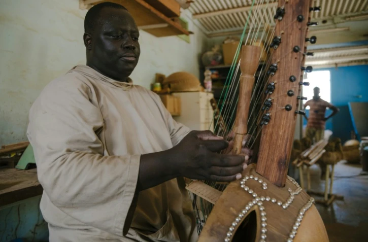 Le frère Marie Firmin joue de la kora dans l'atelier de l'abbaye de Keur Moussa, au Sénégal, le 19 mai 2021