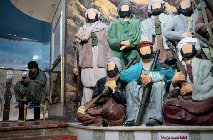 Un visiteur s'assoit près de statuettes représentant des moudjahidine sans visage au "musée du Jihad" dans la province d'Herat, en Afghanistan, le 6 janvier 2026