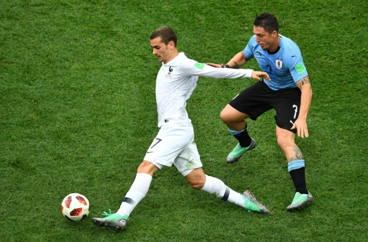 L'attaquant français Antoine Griezmann (g) marqué par le milieu uruguayen Cristian Rodriguez lors du quart de finale, à Nijni Novgorod, le 6 juillet 2018