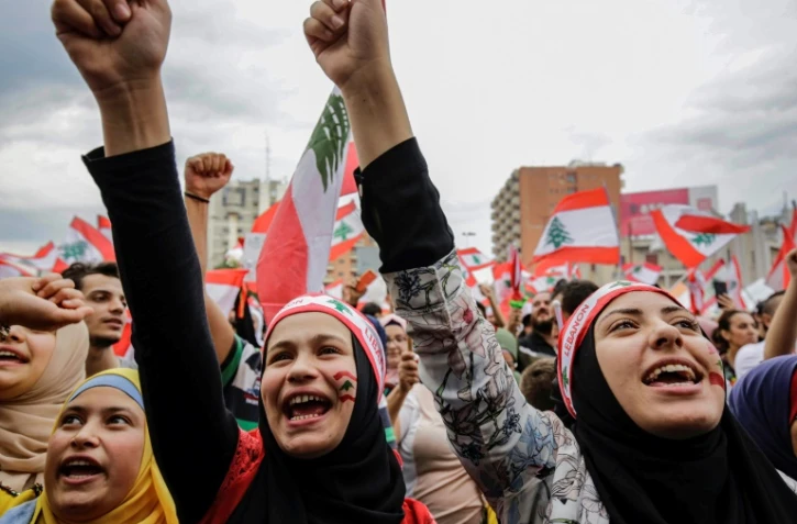 Des Libanaises scandent des slogans lors d'une manifestation sur la place al-Nour à Tripoli dans le nord du pays, le 23 octobre 2019, au septième jour de protestation contre les hausses d'impôts et la corruption officielle