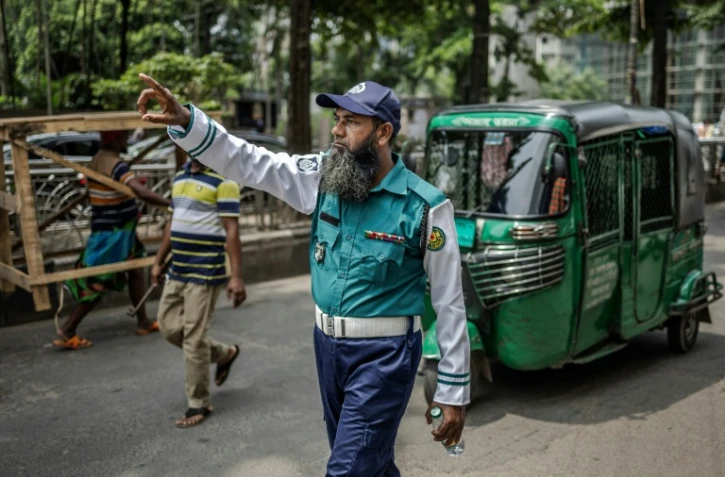 Un policier régule la circulation à Dacca, le 12 août 2024 au Bangladesh