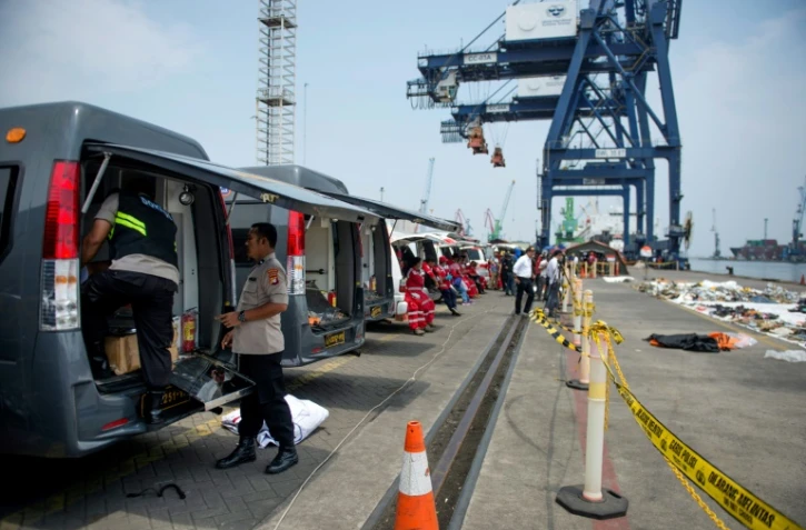 Des ambulances positionnées sur un quai du port de Jakarta pour emporter les corps des victimes du vol Lion Air récupérés par les secouristes