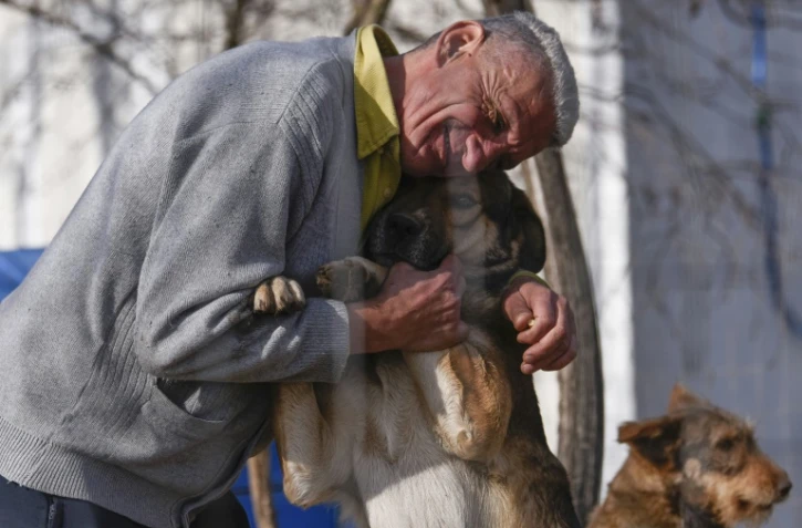 Slavisa Stojanovic serre contre lui un chien du refuge pour chiens abandonnés, le 12 novembre 2021 près de Gracanica, au Kosovo