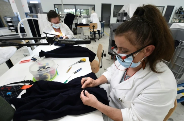 Des employés de la PME 3D Tex retravaillent les mails de pulls sortis d'un métier à tisser, le 17 septembre 2021 à Sain-Malo