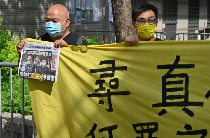 Des supporteurs du rédacteur en chef Ryan Law et du directeur général CHueng Kim-hung de l'Apple Daily devant le tribunal de Hong Kong, le 19 juin 2021