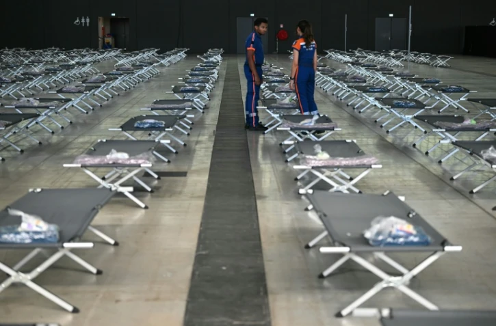 Des membres de la protection civile préparent des lits pour accueillir les personnes déplacées par le mégafeu en Gironde, le 28 juillet 2026 à Aussonne, près de Toulouse