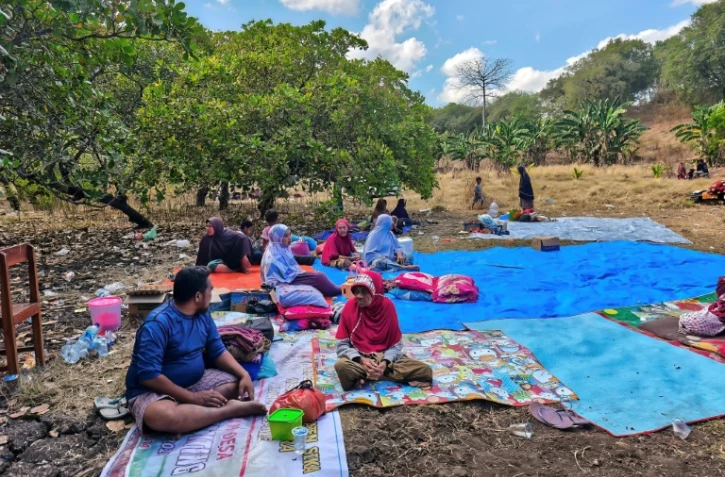 Des habitants ont passé la nuit dehors après le puissant séisme qui a secoué l'île indonésienne de Florès, dans l'est de l'archipel, le 16 août 2026 à Sikka, dans la province de Nusa Tenggara Est