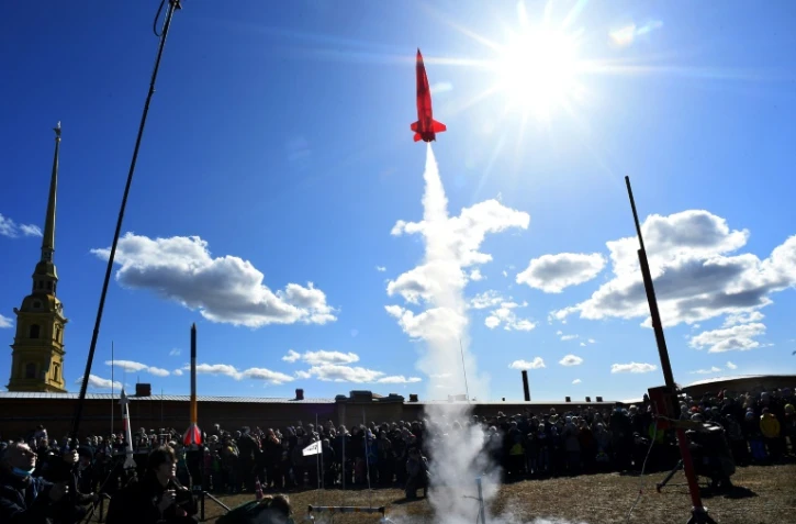 Des spectateurs regardent le lancement de modèles réduits de fusées, à Saint-Pétersbourg, le 11 avril 2021, alors que La Russie célèbre la conquête de l'espace par Gagarine il y a 60 ans