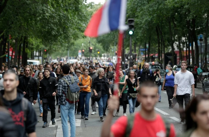 Des gens manifestent à Paris contre les annonces d'Emmanuel Macron sur le pass sanitaire, la vaccination et la "dictature", le 14 juillet 2021. 