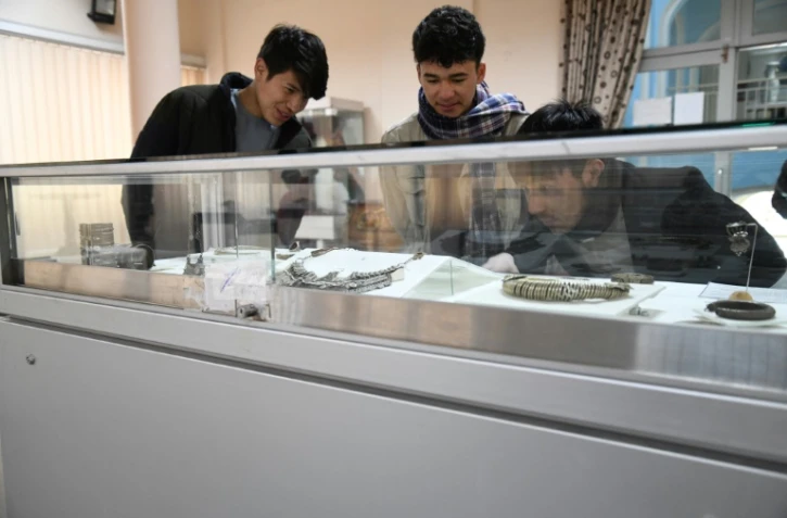 Des visiteurs admirent des objets du musée national d'Afghanistan, le 12 décembre 2021 à Kaboul