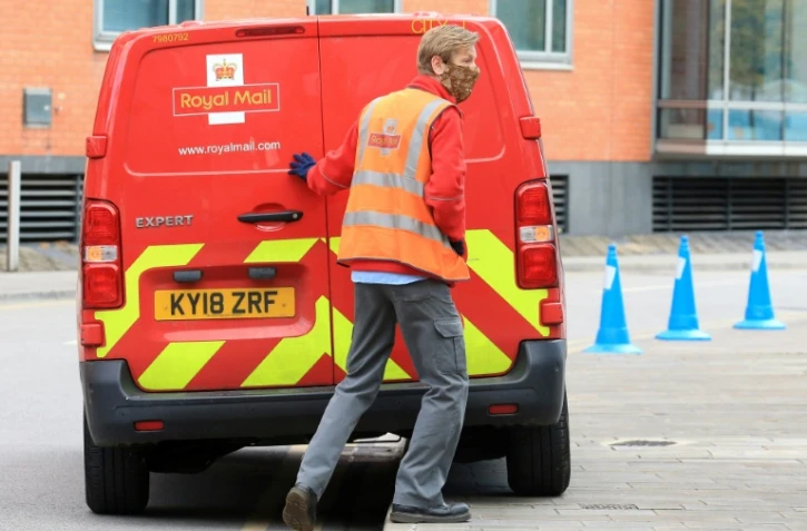 Un employé de la poste fait sa tournée dans les rues désertes de Leeds, dans le nord de l'Angleterre, le 2 mai 2020