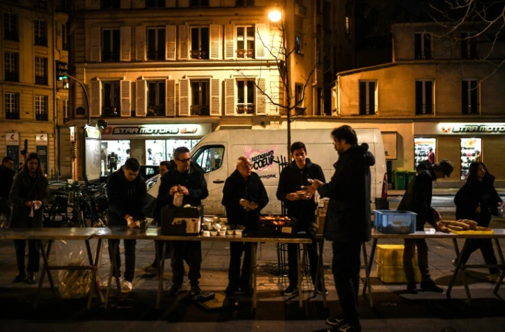 Des bénévoles des "Restos du coeur" mettent en place un point de distribution alimentaire, à Paris le 21 mars 2023
