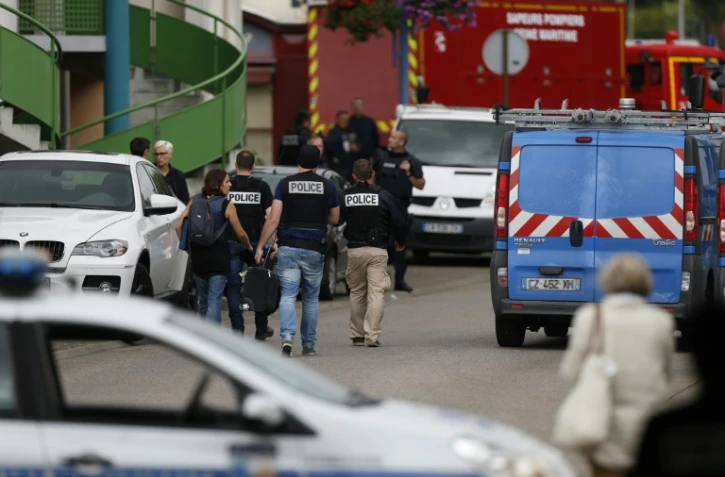 Policiers et pompiers se positionnent autour de l'église de Saint-Etienne-de-Rouvray où a eu lieu une prise d'otages et où un prêtre a été égorgé, le 26 juillet 2016