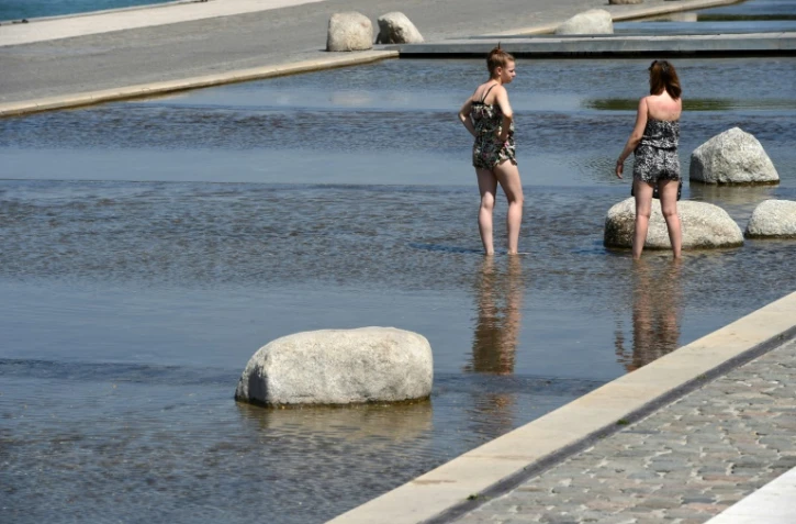 Des femmes se rafraîchissent dans une fontaine à Lyon, en août 2015