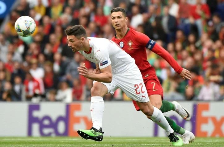 Le défenseur suisse Fabian Schar (g) devance la star du Portugal Cristiano Ronaldo auteur d'un triplé en demi-finale de la Ligue des Nations, le 5 juin 2019 à Porto 