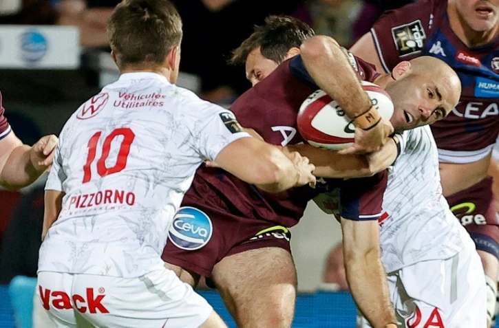 Le demi de mêlée de l'UBB Maxime Lucu (balle en main) charge les Toulonnais Louis Carbonel et Baptiste Serin à Bordeaux, le 1er mai 2022 
