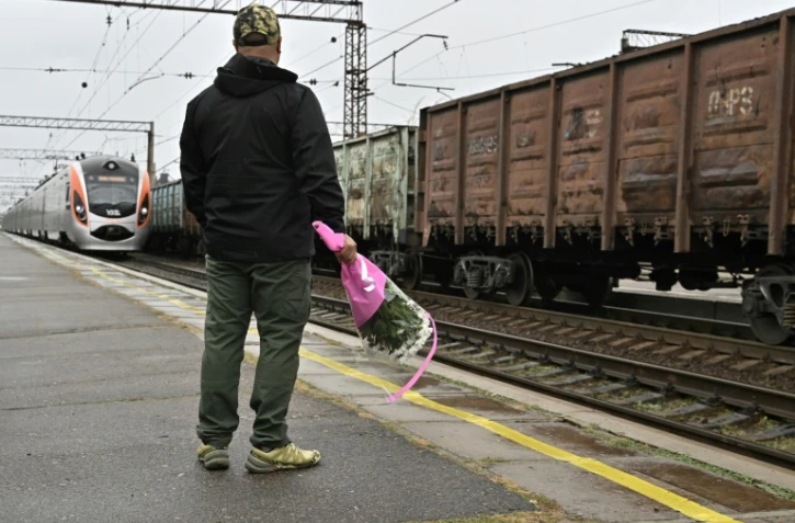 Un homme, un bouquet de fleurs Ă la main, attend le train arrivant de Kiev Ă la gare de Kramatorsk, le 8 octobre 2023 en Ukraine