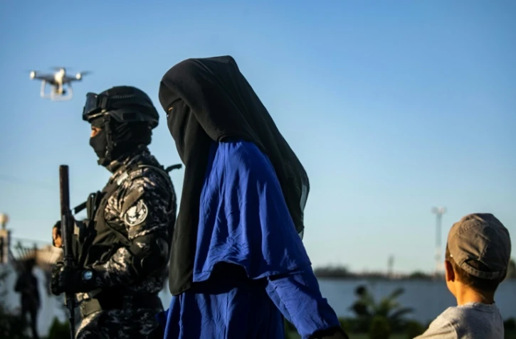 Un soldats des Forces démocratiques syriennes (FDS) escorte une femme voilée et un enfant, le 19 mai 2019 à Qamichli, en Syrie