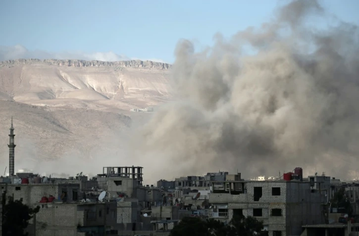 De la fumée s'élÚve sur la ville rebelle de Erbine, dans la Ghouta orientale assiégée, aprÚs une frappe, le 2 janvier 2018
