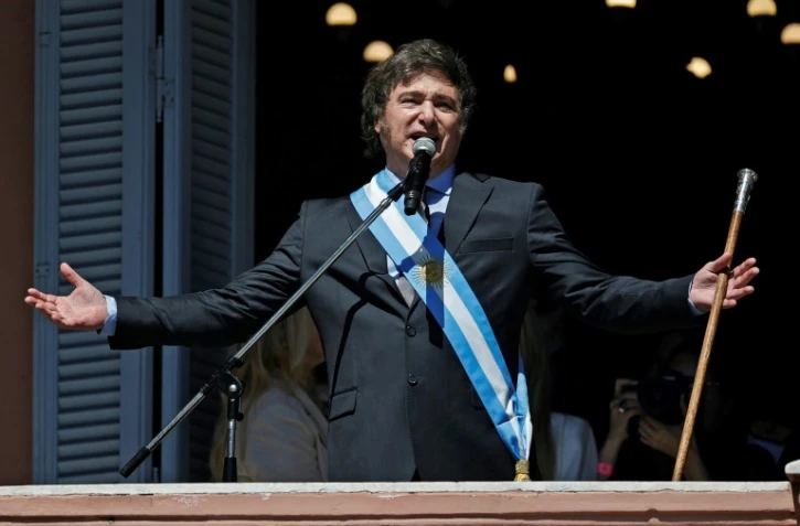 Le président argentin Javier Milei salue la foule depuis le balcon du palais présidentiel, le 10 décembre 2023 à Buenos Aires