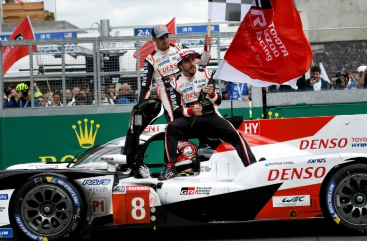 L'Espagnol Fernando Alonso (d), le Suisse Sebastien Buemi (g) et le Japonais Kazuki Nakajima (au volant) lors de la victoire aux 24 Heures du Mans le 16 juin 2019