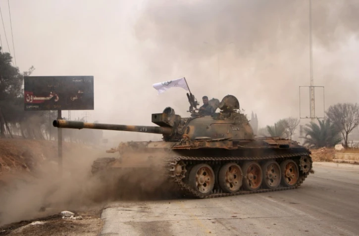 Des rebelles syriens se réclamant de l' Armée de la Conquête manoeuvrent un tank T-55 lors d'un assaut sur les forces pro-régime à Alep, le 28 octobre 2016