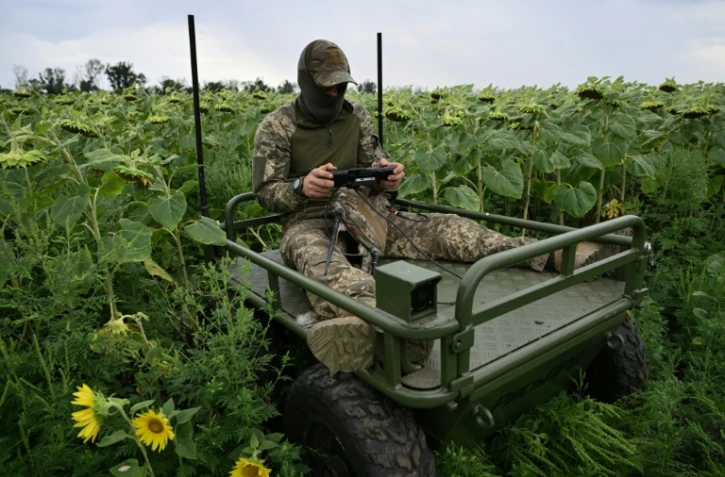 Un soldat ukrainien fait une démonstration de robot piloté à distance permettant d'évacuer des soldats blessés du front, dans l'est de l'Ukraine, le 11 août 2025
