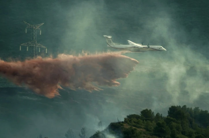 Un avion de lutte contre les incendies largue des produits ignifuges sur des arbres lors d'un incendie de forêt près de Fontcouverte, dans l'Aude, le 5 juillet 2025