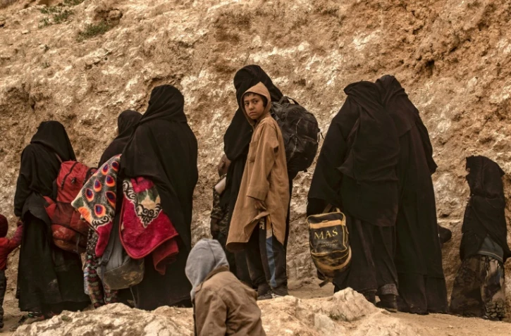 Des membres présumés du groupe Etat islamique (EI) fuient le village de Baghouz (Syrie), le 14 mars 2019