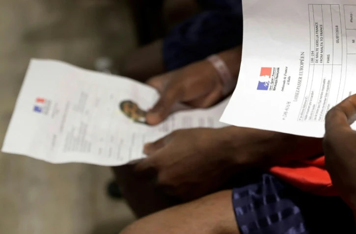 Un migrant avec en main un Laissez-Passer Européen à l'aéroport Roissy-Charles de Gaulle, près de Paris, le 5 juillet 2018