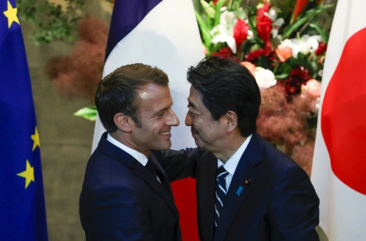 Le président français  Emmanuel Macron (L) accueilli par le Premier ministre japonais Shinzo Abe avant une rencontre à Tokyo le 26 juin 2019