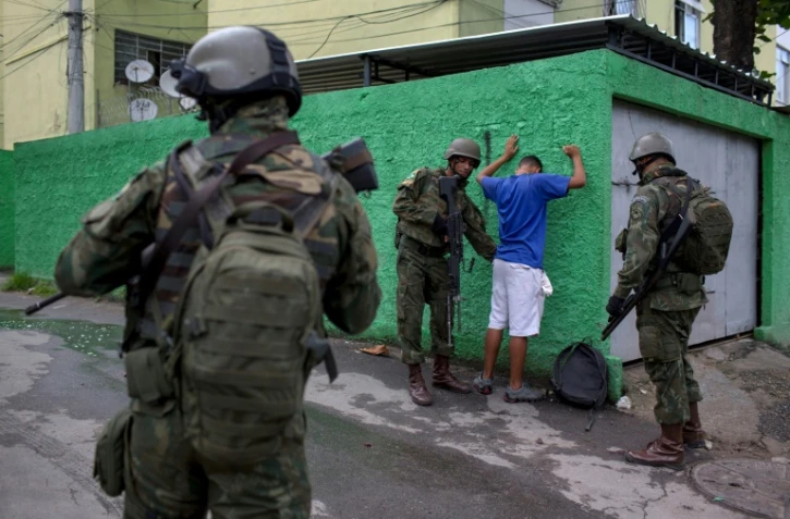 Des soldats de l'armée brésilienne fouillent un résident lors d'une opération conjointe à la favela "Cidade de Deus" à Rio de Janeiro, le 7 février 2018