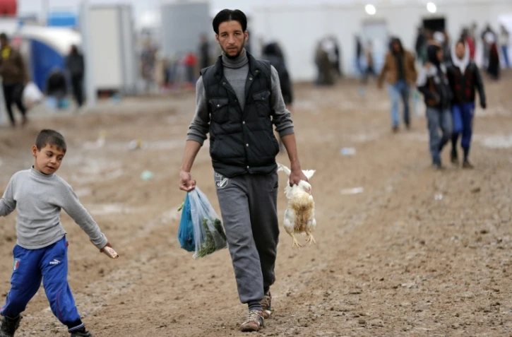 Un déplacé du nord de l'Irak, dans le camp d'Al-Khazir, rapporte des provisions, le 1 décembre 2016