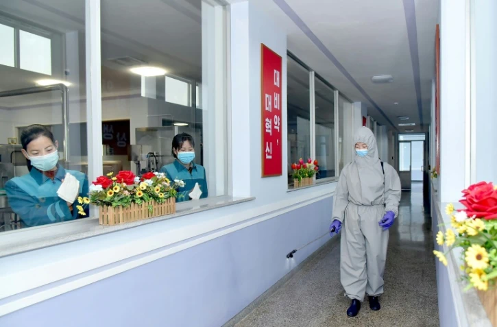 Désinfection d'une usine d'eau minérale à Pyongyang le 20 mars 2021