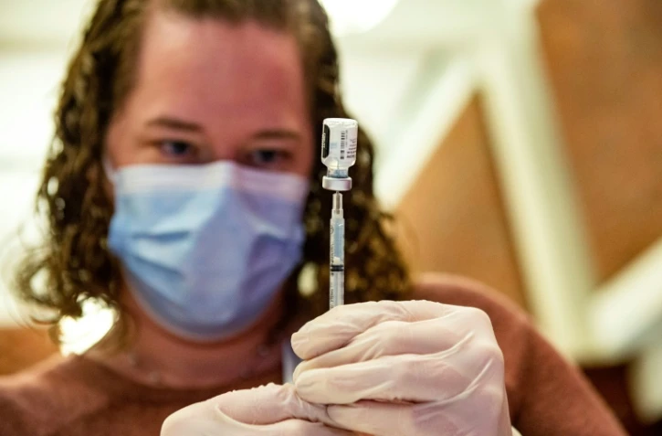 Un soignant d'un hôpital à Hartford (Connecticut) prépare à injecter à un patient une dose de vaccin contre le Covid-19 le 6 janvier 2022