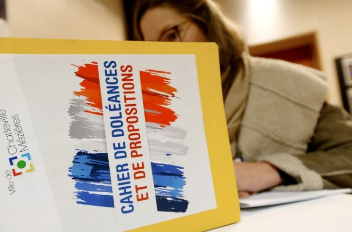 Une femme écrit dans un cahier de doléances qui sera présenté au Premier ministre à Charleville-Mezières, le 20 décembre 2018