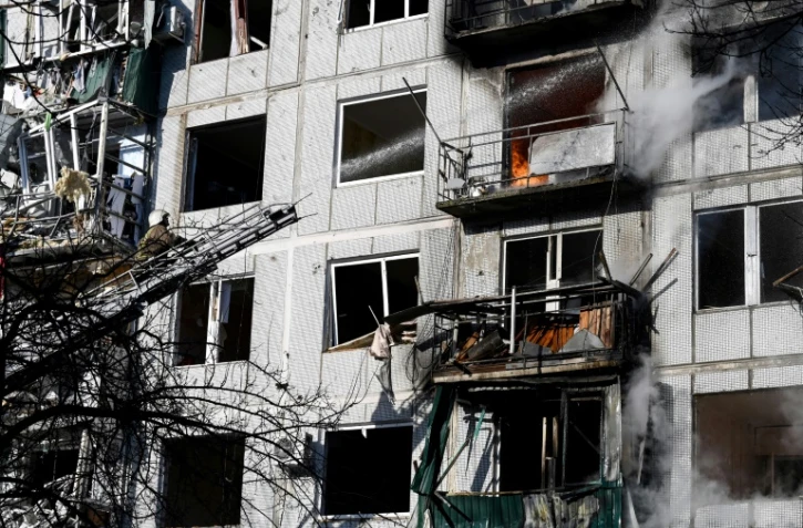 Les pompiers tentent d'éteindre un incendie dans un immeuble après un bombardement à Tchouhouïv (Ukraine) le 24 février 2022