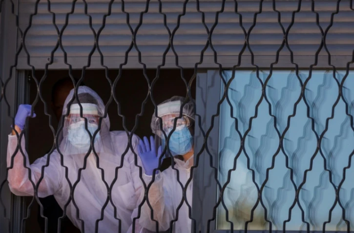 Une équipe d'agents désinfectent une résidence pour personnes handicappées, à Getafe, dans la banlieu de Madrid, le 25 mars 2020