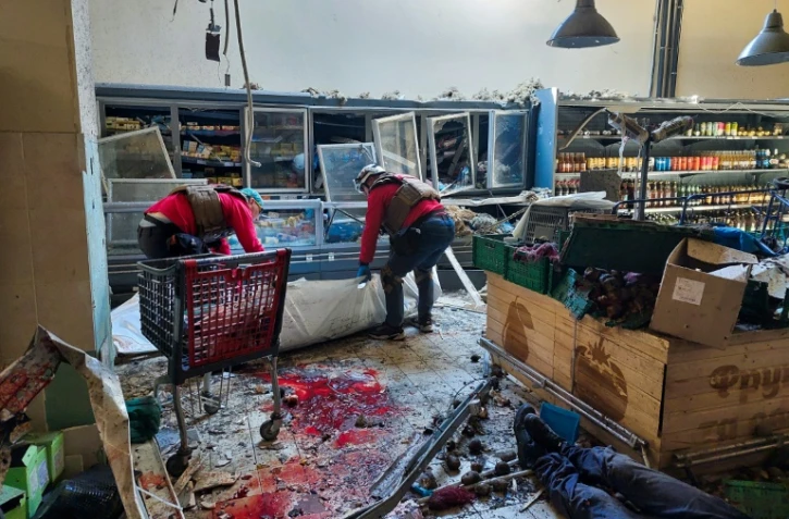 Des secouristes ukrainiens emmènent les corps de civils tués dans une frappe russe sur un supermarché de Kherson (sud) le 3 mai 2023
