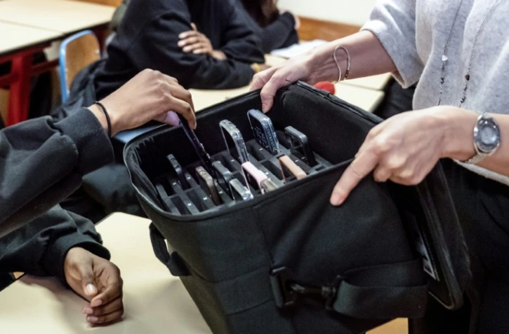 Une enseignante récupère les téléphones portables des élèves, mis de côté pendant les cours au lycée professionnel Jean Mermoz de Montsoult, le 14 janvier 2026 dans le Val-d'Oise