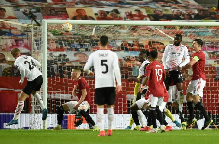 Le défenseur danois de l'AC Milan, Simon Kjaer (g), égalise de la tête en 8e de finale retour de la Ligue Europa sur le terrain de Manchester United, le 11 mars 2021