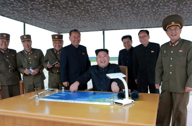 Photo fournie le 30 août 2017 par l'agence officielle nord-coréenne KCNA montrant le leader nord-coréen Kim Jong-Un observer le tir d'un missile Hwasong-12  au-dessus du Japon dans un endroit non précisé