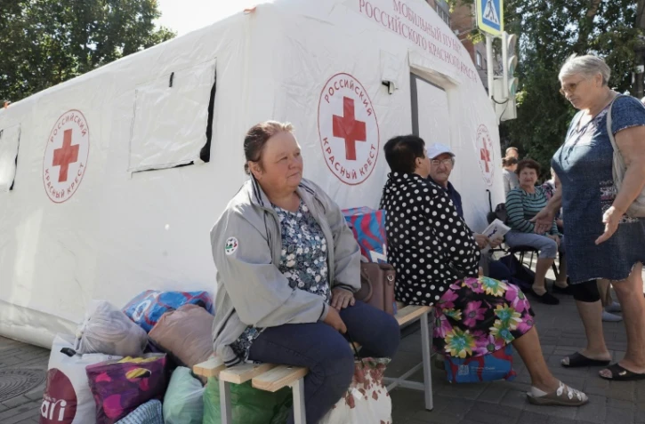 Des personnes déplacées par les combats reçoivent une aide humanitaire au point de distribution de la Croix-Rouge russe à Koursk, le 15 août 2024