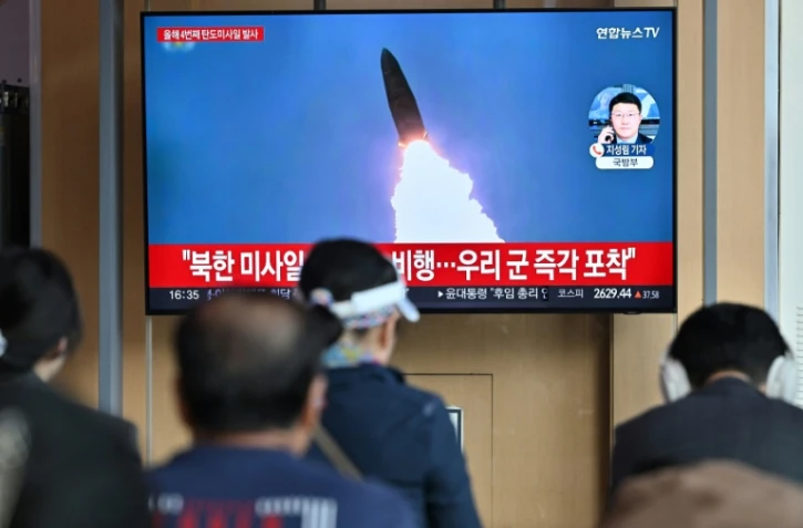 Des personnes devant un écran de télévision montrant des images d'archive d'un essai de missile nord-coréen, dans une gare de Séoul, en Corée du Sud, le 22 avril 2024