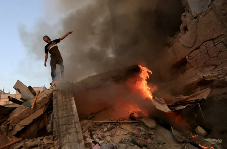 Un homme sur les ruines d'un immeuble détruit par une frappe israélienne sur Khan Younès, dans le sud de la bande de Gaza, le 4 novembre 2023