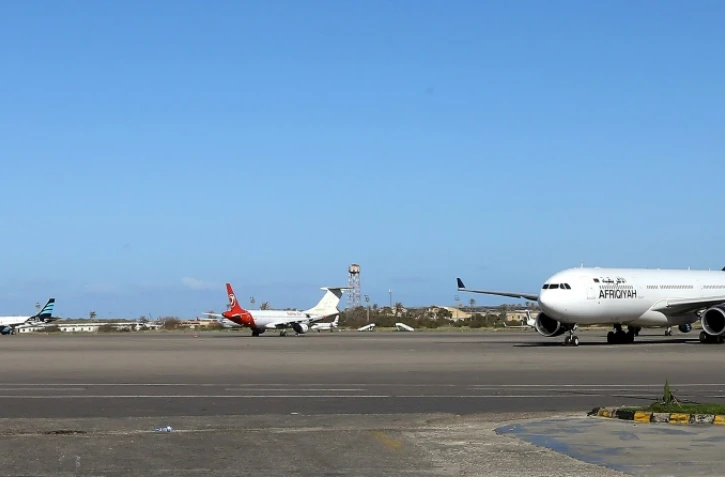 Une photo prise le 8 avril 2019 montre des avions stationnés sur le tarmac de l'aéroport Mitiga dans la capitale libyenne Tripoli