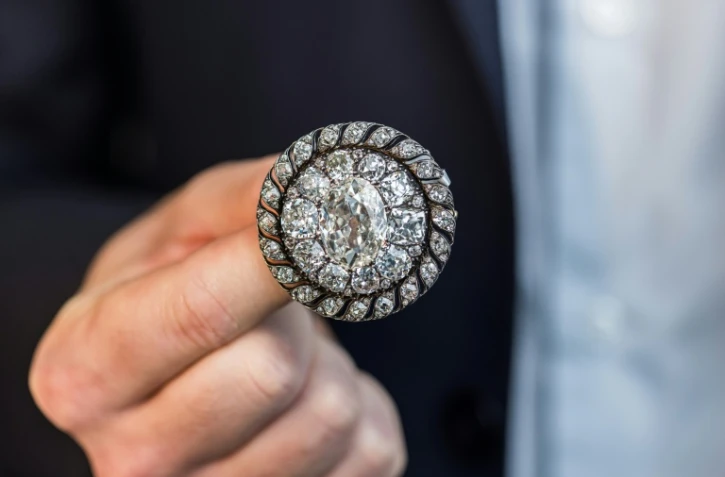Un employé de Sotheby's présente une broche circulaire ornée de diamants anciens ayant appartenu à Napoléon Bonaparte et récupérée par l'armée prussienne après la défaite de Waterloo, avant une vente aux enchères à Genève, le 6 novembre 2025