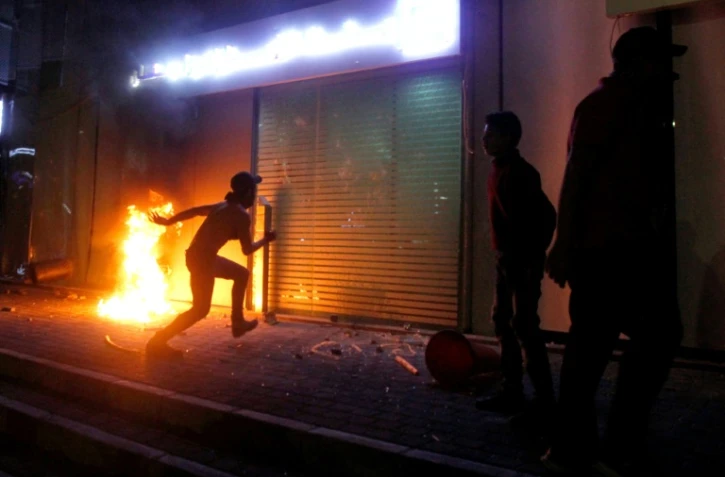 Un manifestant libanais devant l'entrée d'une banque en flammes à Saïda, le 29 avril 2020